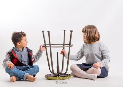 dos niños juegan con un taburete al revés. Fotografia de Elena Rubio para elenircfotografia, fotógrafa infantil Barcelona