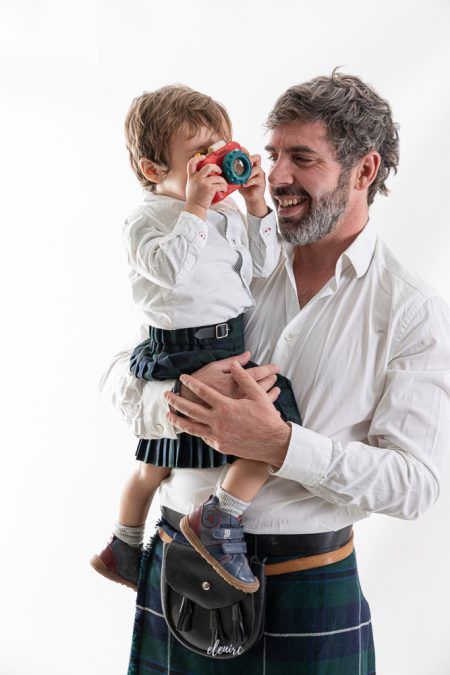 Fotografía infantil con Jan y Clara, creciendo con la familia papá y bebé con falda escocesa fotografia de familia elenirc