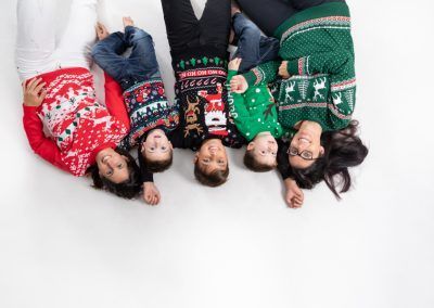 familia lgtbi en sesion de navidad con jerseys navideños en elenirc fogografia fotografo Barcelona Mollet del Vallès