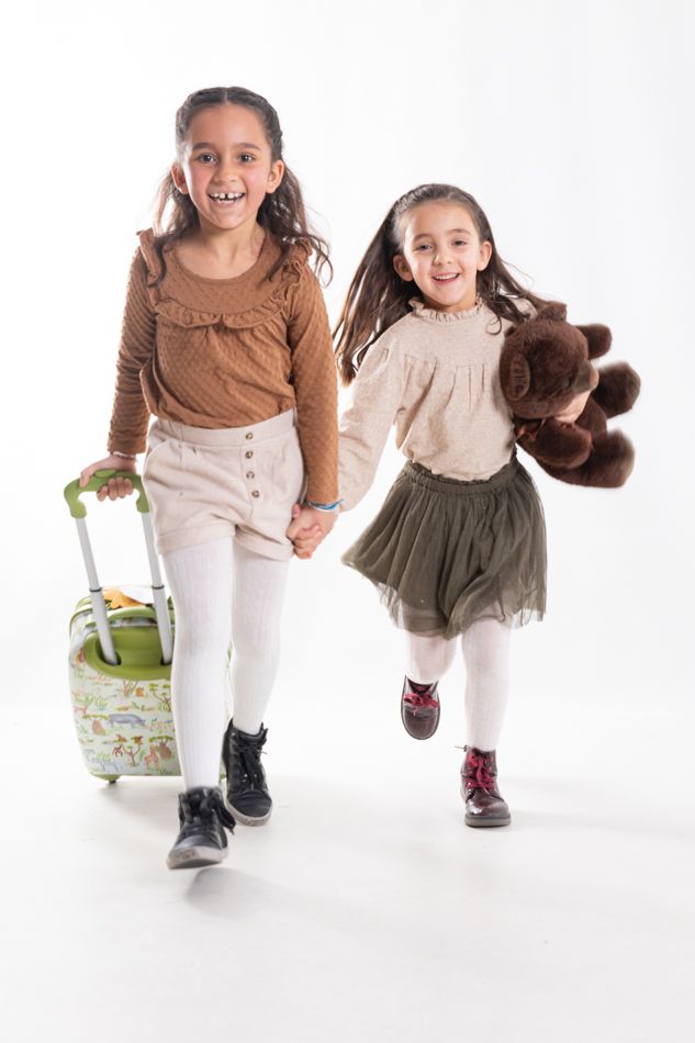 Sesiones de fotos en Barcelona: dos niñas corriendo en estudio con una maleta y un osito de peluche
