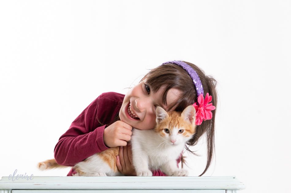 Niña abrazando a un gatito durante una sesión de fotografía infantil en estudio en Mollet del Vallès, por Elenirc Fotografia.