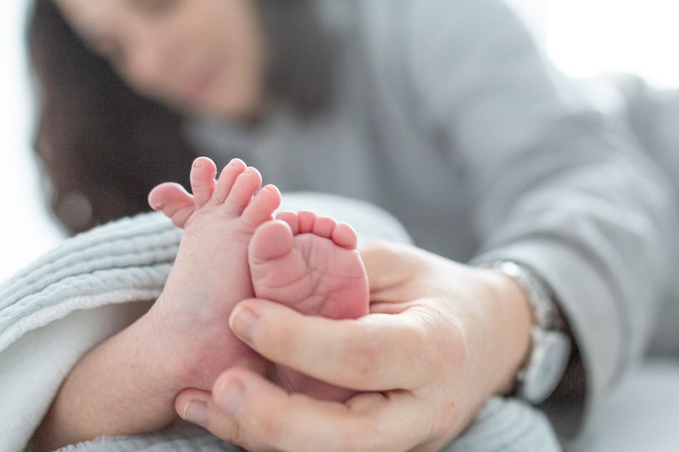 reportaje de recien nacido en casa, pies de recién nacido sujetado por los padres. Sessions de fotos de newborn a casa. fotografia natural de Elena Rubio fotografa de familia elenircfotografia