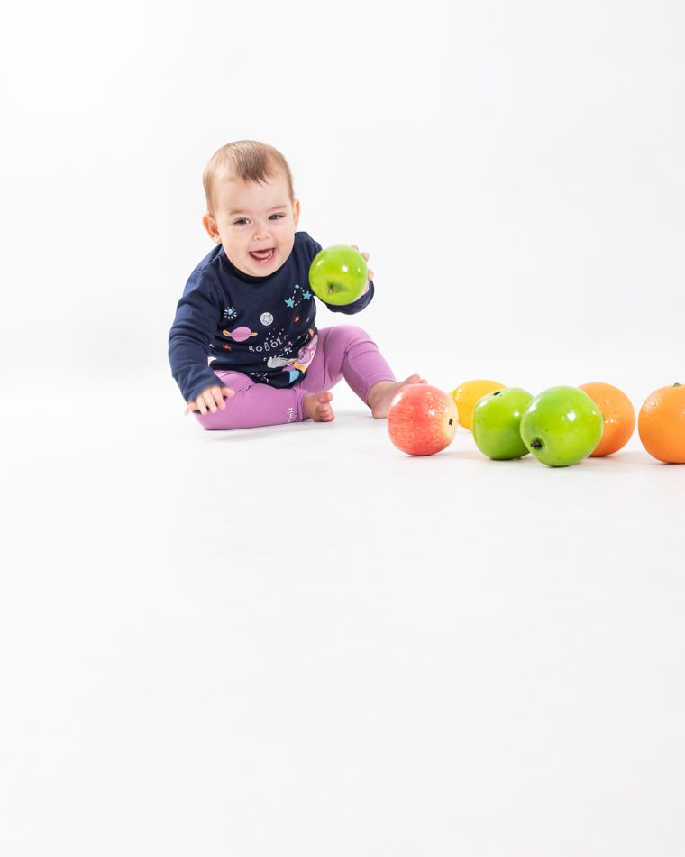 Nara fotografia de bebe de 10 meses gateanto en estudio jugando con fruta elenircfotografia