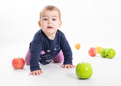 Nahia fotografia de bebe de 10 meses gateanto en estudio mirando de frente elenircfotografia