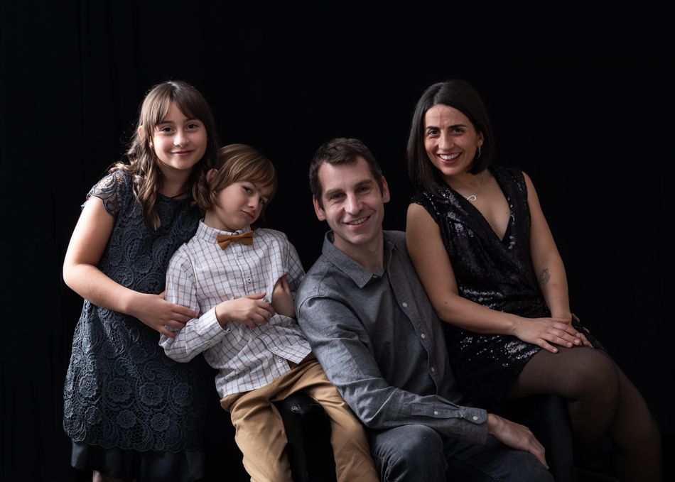 familia con dos niños en estudio en Mollet del Vallès, padres e hijos juntos en un momento cercano, fotografía de familia en Barcelona
