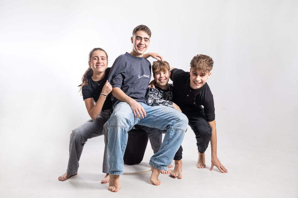 Familia con cuatro hijos en sesión de fotos familiar en estudio, retrato natural y espontáneo en Barcelona.