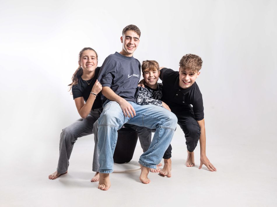 Primos de diferentes edades en estudio | Mollet del Vallès Cuatro primos de diferentes edades, entre infancia y adolescencia, durante una sesión de fotografía familiar en estudio en Mollet del Vallès, creada como regalo para sus abuelos.