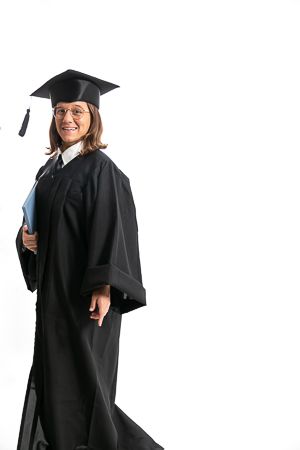 Graduada con toga y birrete sobre fondo blanco en sesión de estudio