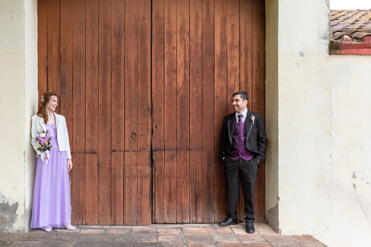 Pareja mirándose antes de la ceremonia frente a una puerta de madera, fotografía documental de boda