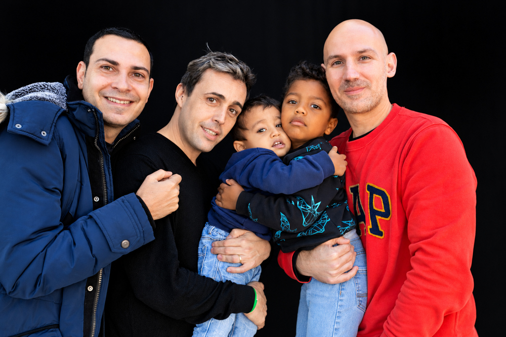 Familia diversa con hijos compartiendo un abrazo durante la Castañada de FLG · Famílies LGTBI+. Fotografía de Elena Rubio · elenirc.