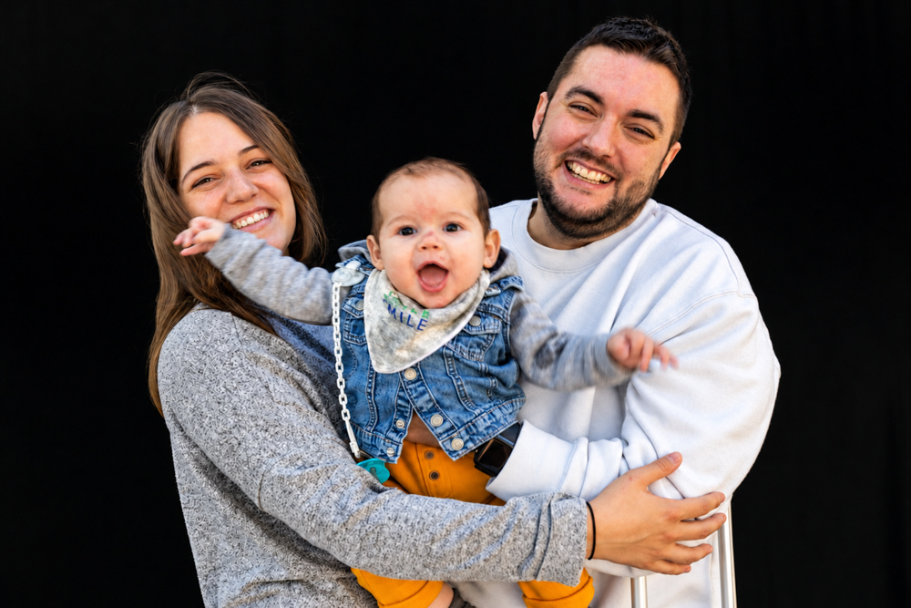 Familia trans con su bebé compartiendo un abrazo durante la Castañada de FLG · Famílies LGTBI+. Retrato de diversidad familiar de Elena Rubio · elenirc.