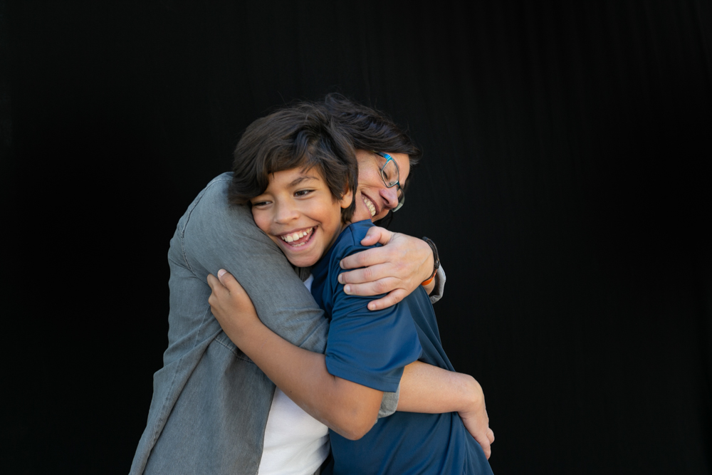 Mamá abrazando a su hijo en un momento de cariño y complicidad. Retrato de familia monoparental de la colección Som famílies a tot arreu. Fotografía de Elena Rubio · elenirc.