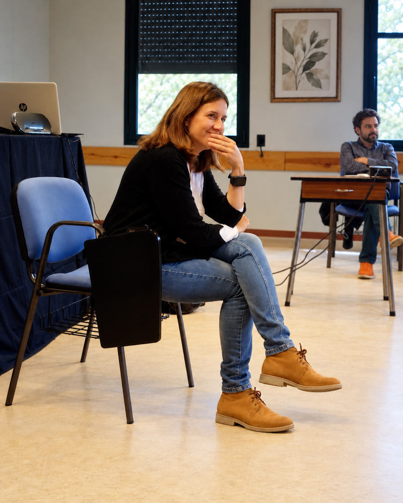 Escucha y comunicación · Retrato de coach Coach sentada y sonriente durante una sesión de gestión emocional. Fotografía documental de taller de gestión de las emociones por Elena Rubio · Elenirc Fotografia.