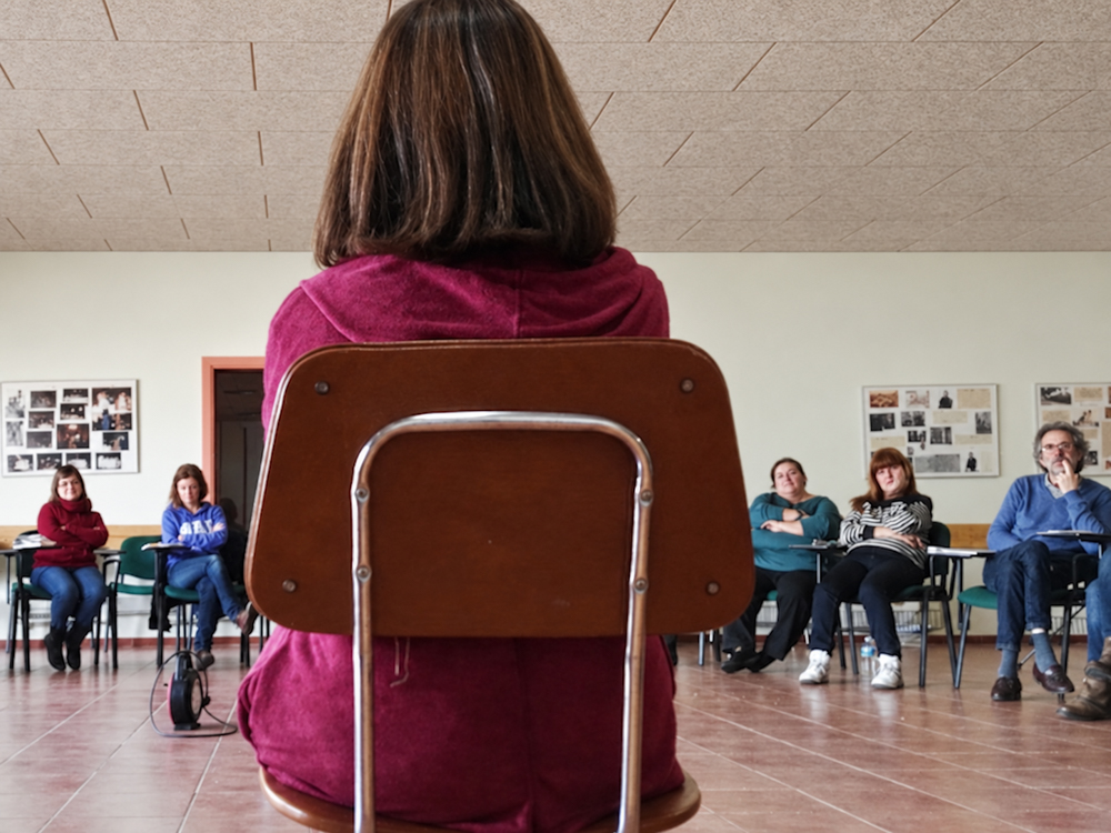 Comunicación y expresión · Coaching grupal Coach de espaldas ante los participantes durante una dinámica de grupo. Fotografía documental de taller de gestión de las emociones Fotografía documental de marca personal por Elena Rubio · Elenirc Fotografia.