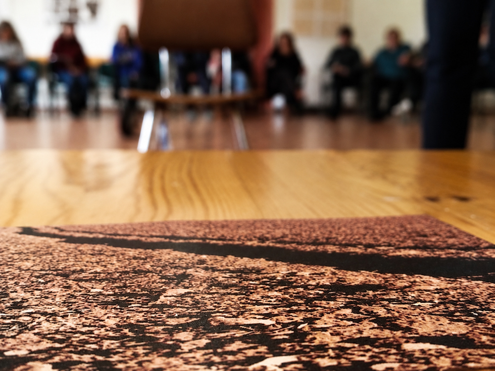 Surcos · Dinámica de grupo y gestión emocional Ficha «Surcos» para una dinámica de gestión emocional, fotografiada en primer plano con los participantes desenfocados al fondo. Fotografía documental de marca personal elenirc fotografia